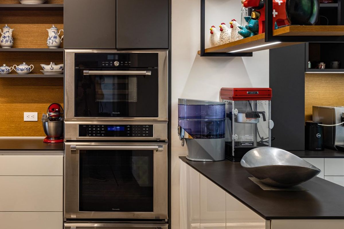 Stainless steel double wall oven built into dark kitchen cabinets